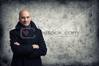 man in coat over cracked wall background