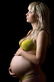 Pregnant girl in yellow lingerie. Isolated