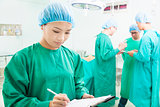 woman Surgeons writing medical record with teams