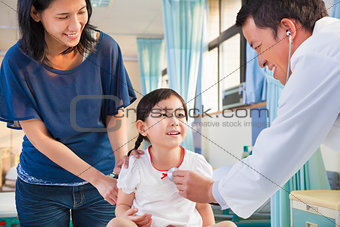 pediatrician examining little girl , her mother beside her