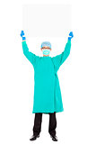 surgeon or checker in mask and holding white board