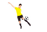 Young soccer player kicking ball 