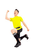 Excited young soccer player raised hand and kneeling down