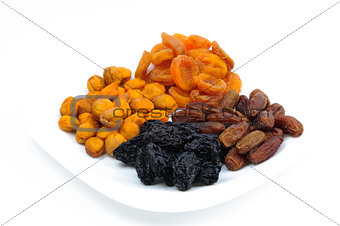 Isolated four heaps of dried fruits apricots, prunes, dates