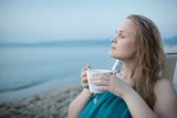 Woman with closed eyes enjoying a cup of tea