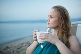 Woman enjoying a cup of tea at the seaside