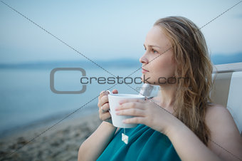 Woman enjoying a cup of tea at the seaside