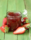 strawberry jam with fresh berries in a jar on the table