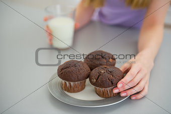 Closeup on young woman taking chocolate muffin