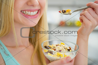 Closeup on happy young woman eating healthy breakfast