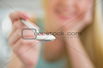 Closeup on young woman giving spoon with yogurt