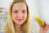 Portrait of young woman with sandwich