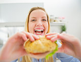 Smiling young woman eating burger