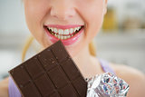 Closeup on young woman eating chocolate