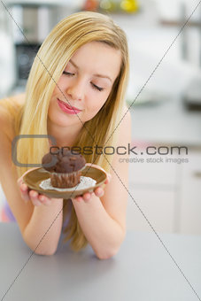 Young woman holding chocolate muffin
