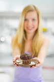 Closeup on young woman showing chocolate muffin