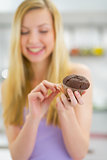 Closeup on young woman eating chocolate muffin