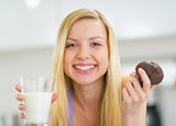 Portrait of happy young woman with milk and chocolate muffin in 