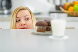 Young woman looking on chocolate muffin