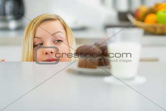 Young woman looking on chocolate muffin