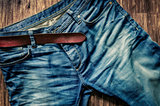 Detail of blue jeans with leather belt in vintage style