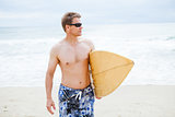 Relaxed looking man walking with surfboard at beach