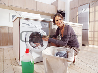 woman putting cloth into washing machine