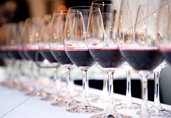 Glasses of red wine in a row on a table 