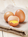 raw chicken eggs one open with yolk
