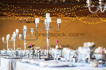 Wedding reception hall with decor including candles, cutlery and