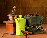 Still life of coffee beans and coffee maker on vintage wooden background