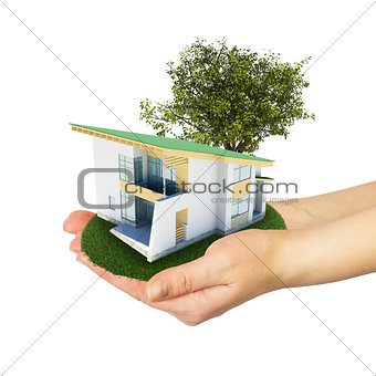 Hands holding a small house with land