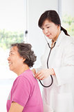 home doctor measuring senior woman blood pressure
