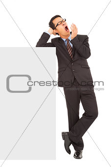 businessman yawning and standing  with blank board