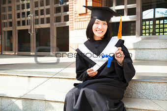 Asian college student holding a diploma at campus