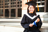 pretty college student holding a diploma at campus