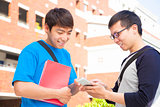 two students using a cell phone  to discuss