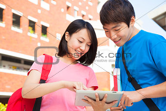 pretty woman using a tablet to discuss homework with a friend