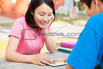 smiling young girl using a tablet  with a friend 