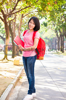 young student girl standing and holding books at campus