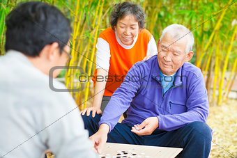 seniors play traditional chinese board game Go
