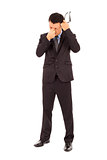 businessman rubbing his eyes and holding glasses