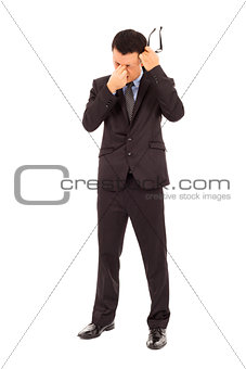 businessman rubbing his eyes and holding glasses