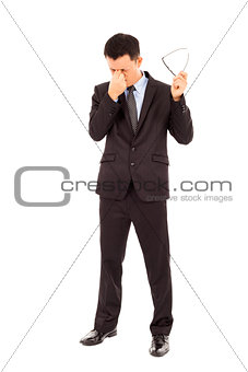 young businessman rubbing his eyes and holding glasses