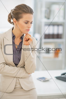 Portrait of thoughtful business woman standing in office