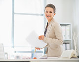 Happy business woman working in office with documents
