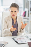 Portrait of business woman in office explaining something