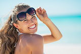 Portrait of happy young woman in sunglasses on beach