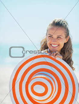 Portrait of smiling young woman with hat on beach