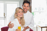 Young couple with orange glass at home